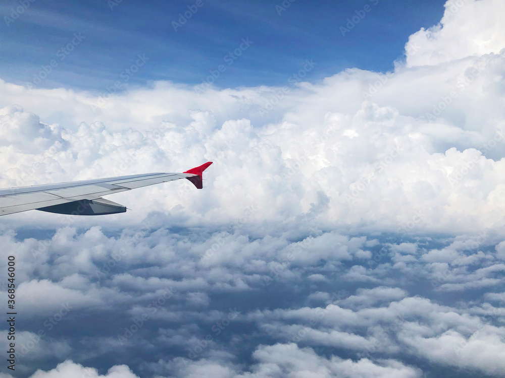 Wing of airplane flying above cloud Wing of airplane flying above cloud