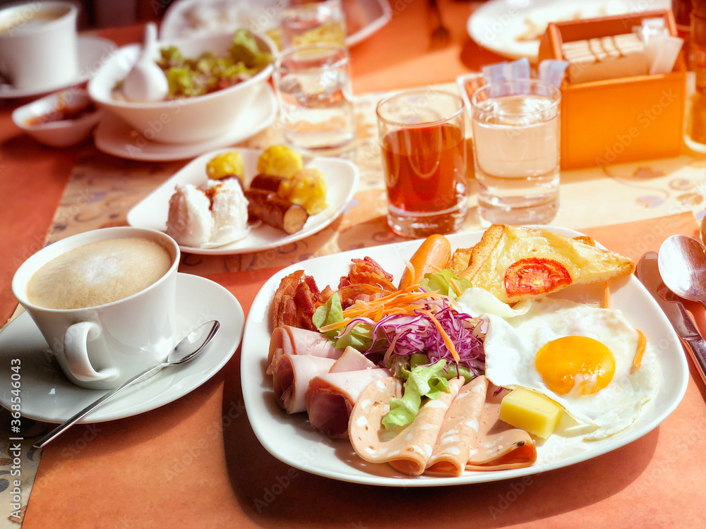 Delicious breakfast served with coffee, orange juice, egg, ham, salad, bacon rolls at the luxury hotel Delicious breakfast served with coffee, orange juice, egg, ham, salad, bacon rolls at the luxury hotel