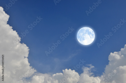Romantic and charming full moon in blue sky with white clouds