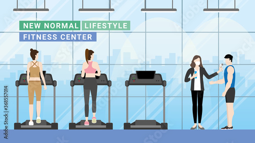 Fitness center a new normal lifestyle. Woman running on a treadmill. Social distancing, Thermal check, and Hand sanitizing at the entrance.