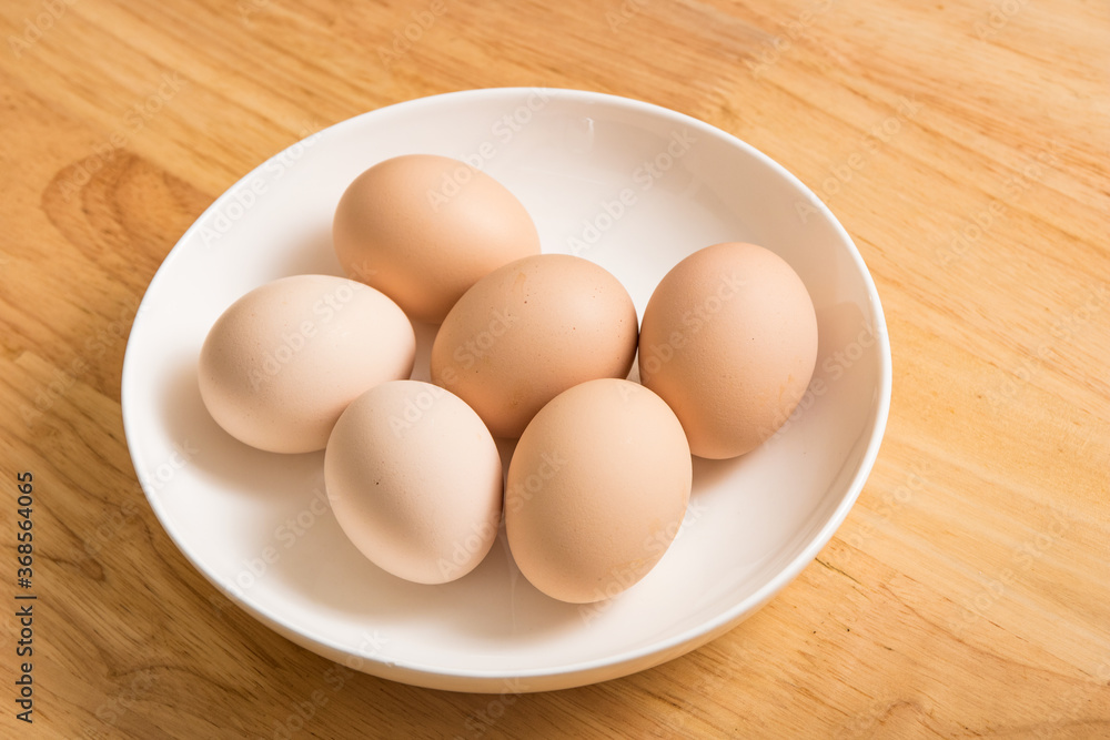 A dish of fresh earthy eggs on the wood-grain table A dish of fresh earthy eggs on the wood-grain table