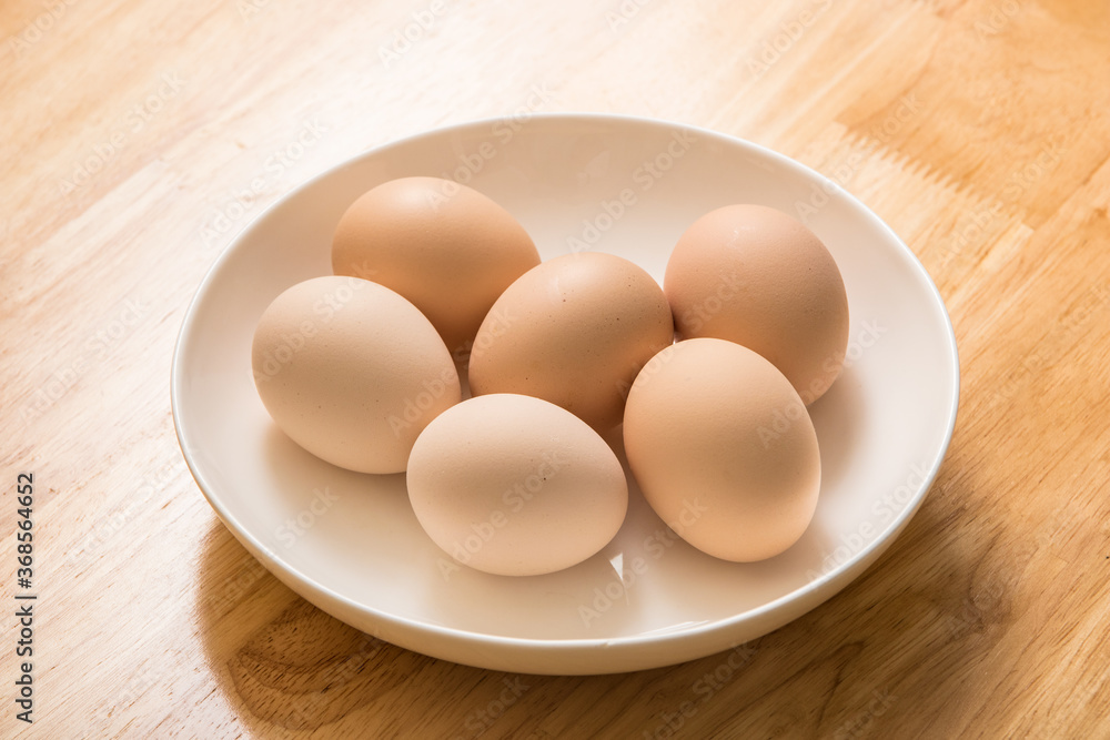 A dish of fresh earthy eggs on the wood-grain table A dish of fresh earthy eggs on the wood-grain table