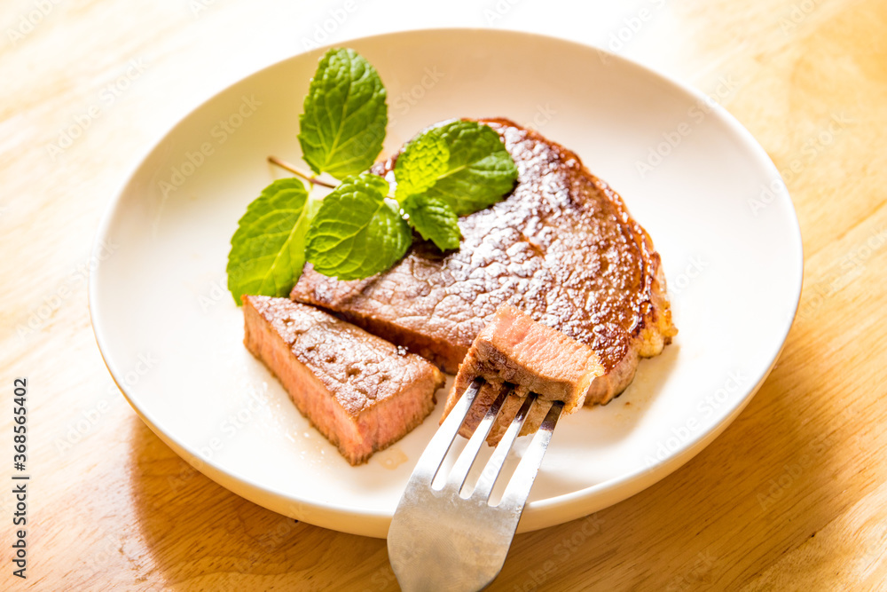 A fine steak dinner on a wood-grain table A fine steak dinner on a wood-grain table