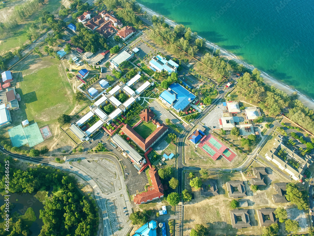 An aerial view of the building beside a beautiful beach.