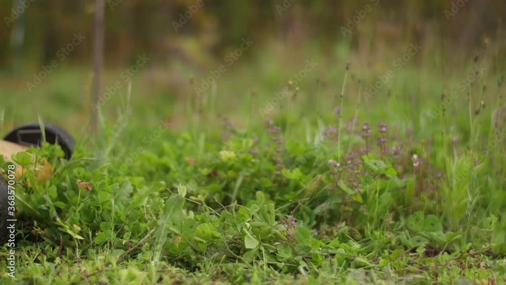 gardener with lawn mower cutting green grass in backyard slow motion gardener with lawn mower cutting green grass in backyard slow motion