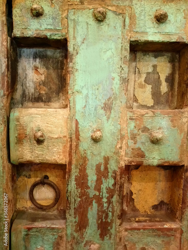 Vintage rustic looking wooden green door with artistic details