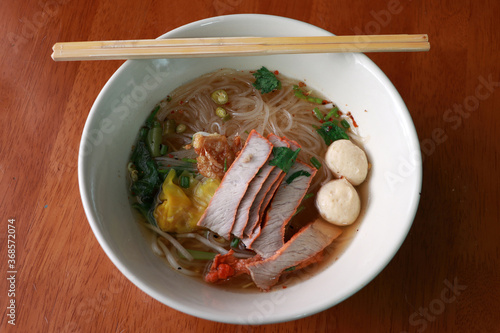 Rice noodle soup and wonton with barbecued red pork and meat ball in the bowl.