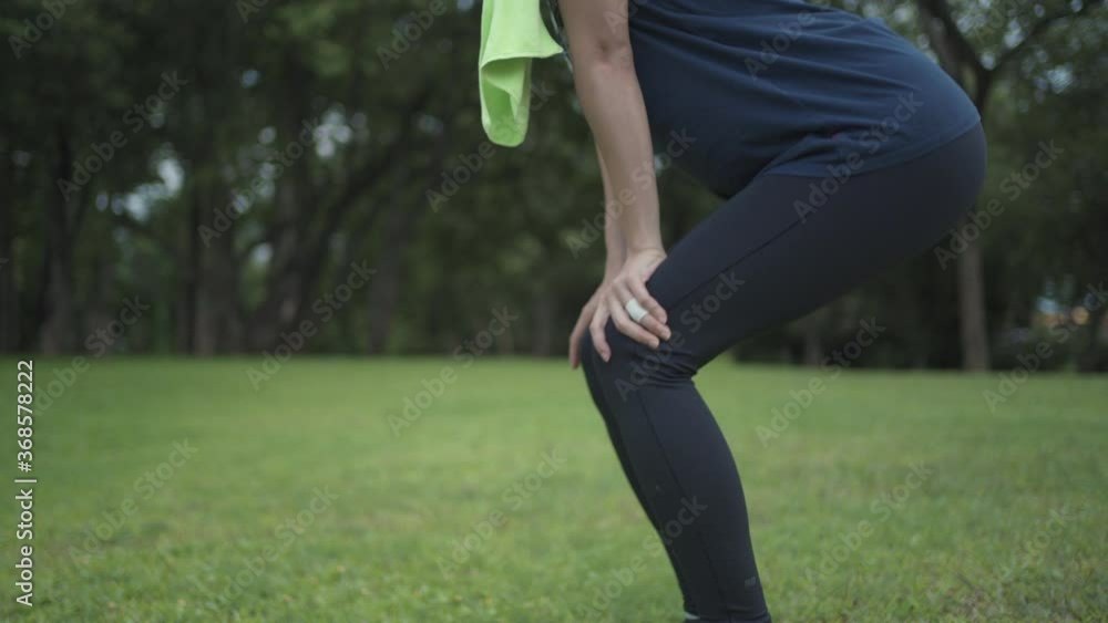 Active young woman doing knees muscle warm up exercise at the park