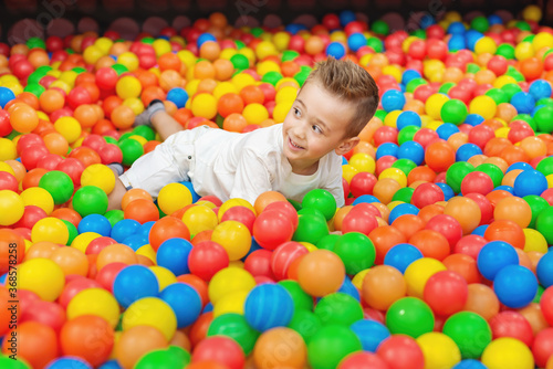 Little smiling child playing and having a good time in kids zone