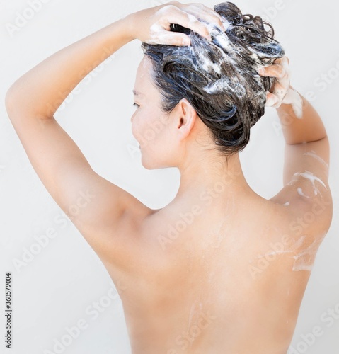 Sexy woman washing her hair in the bathroom.