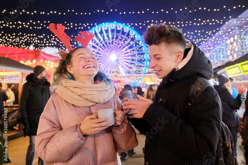 Young people, couple of teenagers having fun at Christmas market