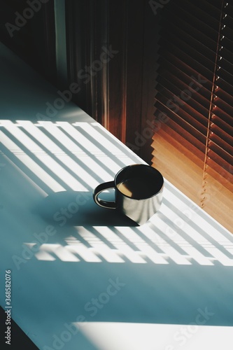 Morning coffee by the office window blind