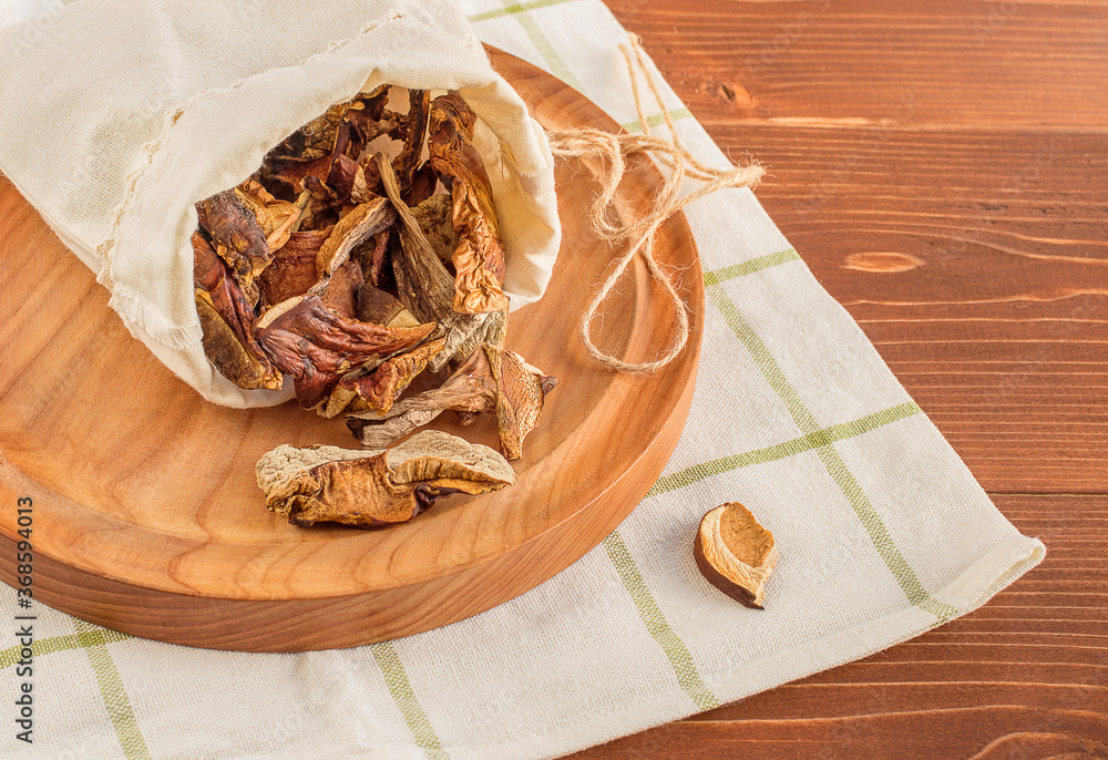 Dried mushrooms in a canvas bag on a wooden table. Organic, eco-friendly food Dried mushrooms in a canvas bag on a wooden table. Organic, eco-friendly food