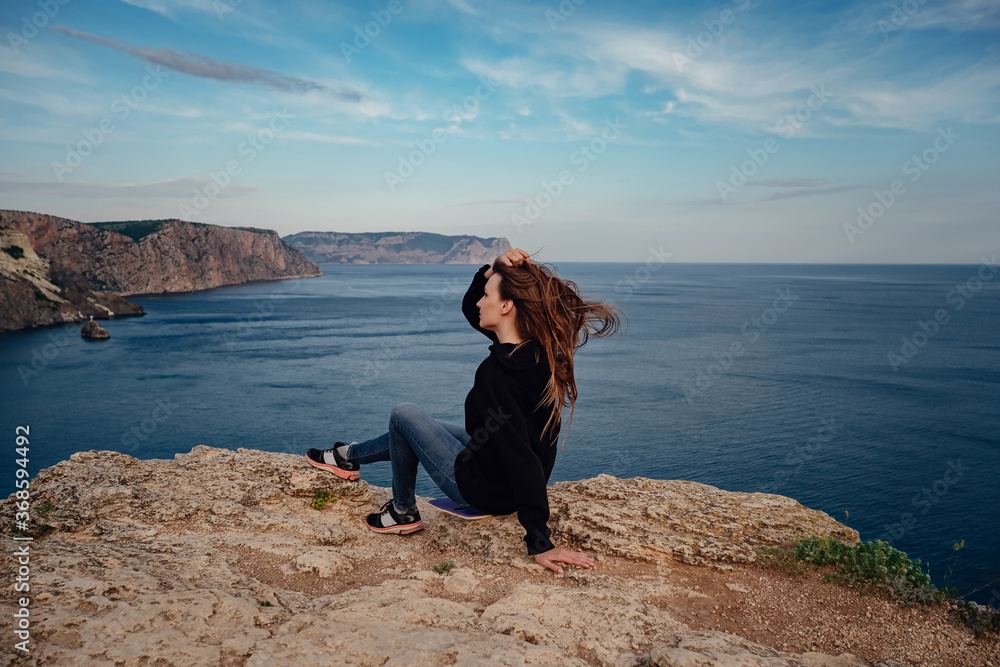 Woman above cold sea on cliff alone. Travel Lifestyle concept