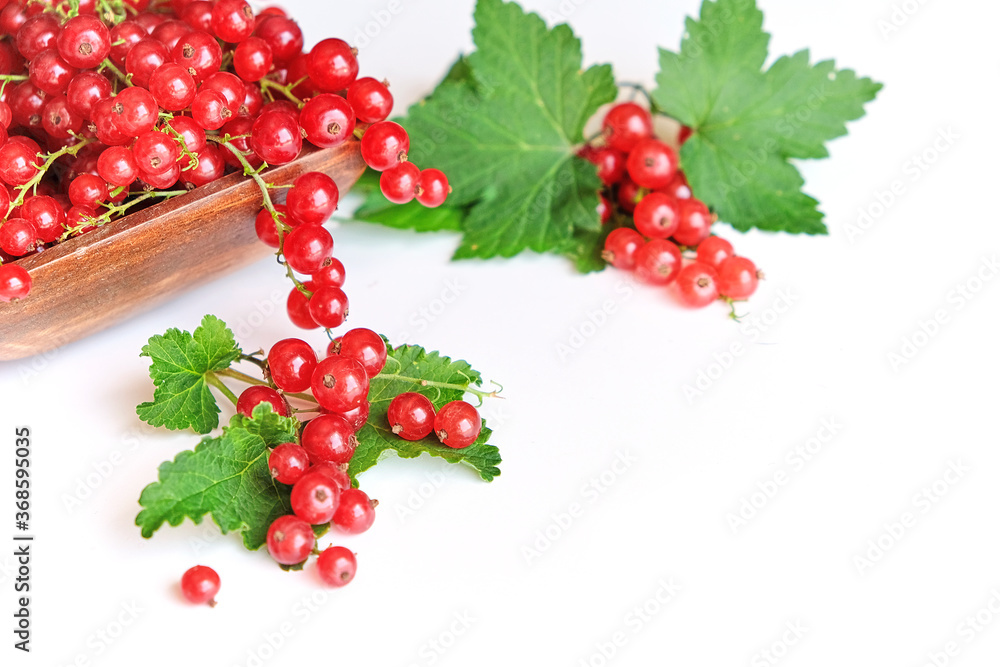 fresh red currant in a wooden bowl isolated on white background. summer harvest of vitamins. fresh red currant in a wooden bowl isolated on white background. summer harvest of vitamins.