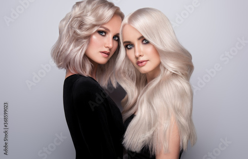 Fotografie Two beautiful girls with hair coloring in blond