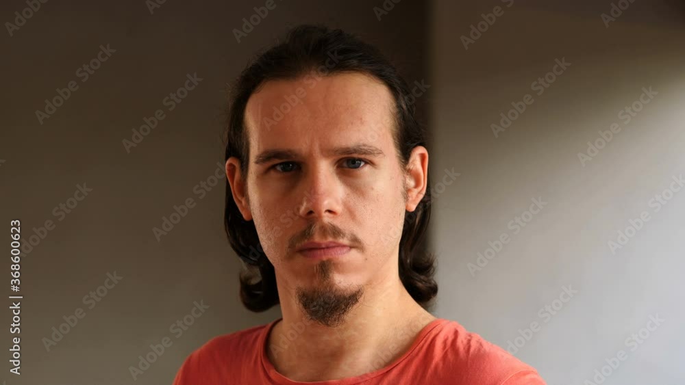 young pensive man looking up and staring at camera young pensive man looking up and staring at camera