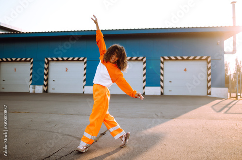 African American girl - dancer dancing in the street at sunset. Sport, dancing and urban culture concept. Fashion lifestyle.