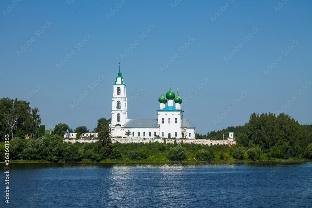 white-stone Trinity Church on the banks of the Volga river in Yaroslavl region Russia on a clear summer day against a blue sky and copy space