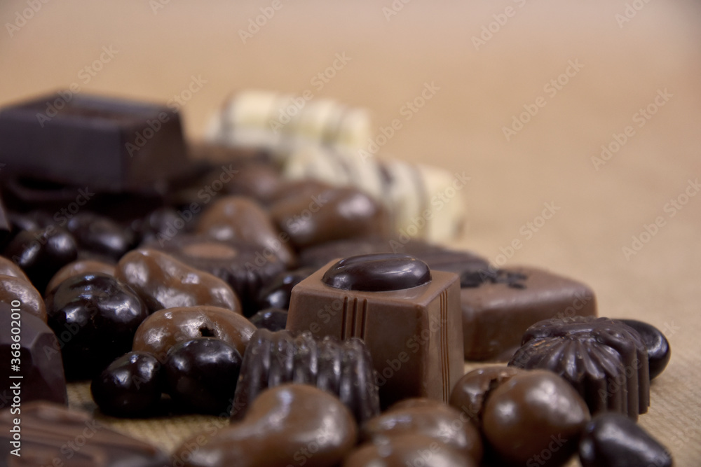 Chocolate pralines on a brown background stock images. Chocolate pralines on a brown background with copy space for text stock images. Various chocolate candies frame. Pile of different chocolates Chocolate pralines on a brown background stock images. Chocolate pralines on a brown background with copy space for text stock images. Various chocolate candies frame. Pile of different chocolates