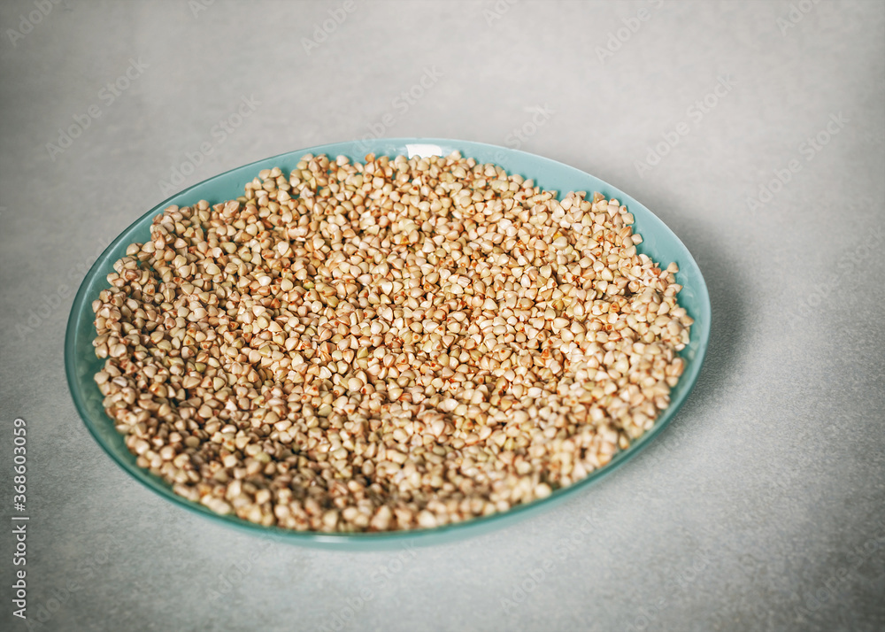 Healthy Food Background. Plate of green buckwheat on a background of light gray stone table. Soaked buckwheat and grains are ready for germination. Healthy Food Background. Plate of green buckwheat on a background of light gray stone table. Soaked buckwheat and grains are ready for germination.