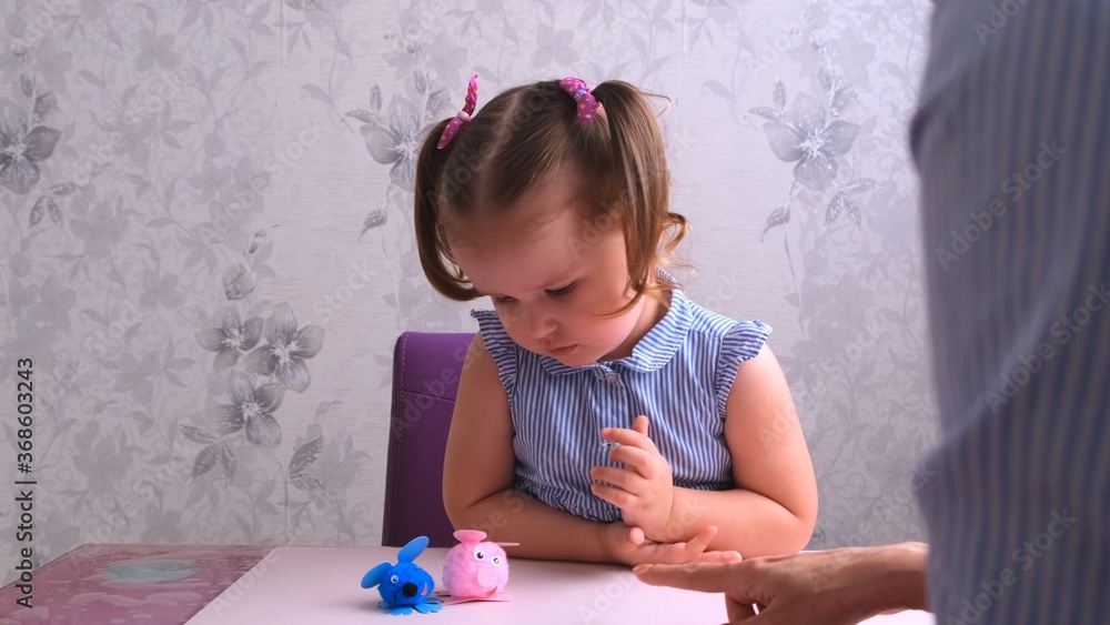 little girl, together with her mother, makes a soft toy pink pig. Everyday moms, craft with children. little girl, together with her mother, makes a soft toy pink pig. Everyday moms, craft with children.