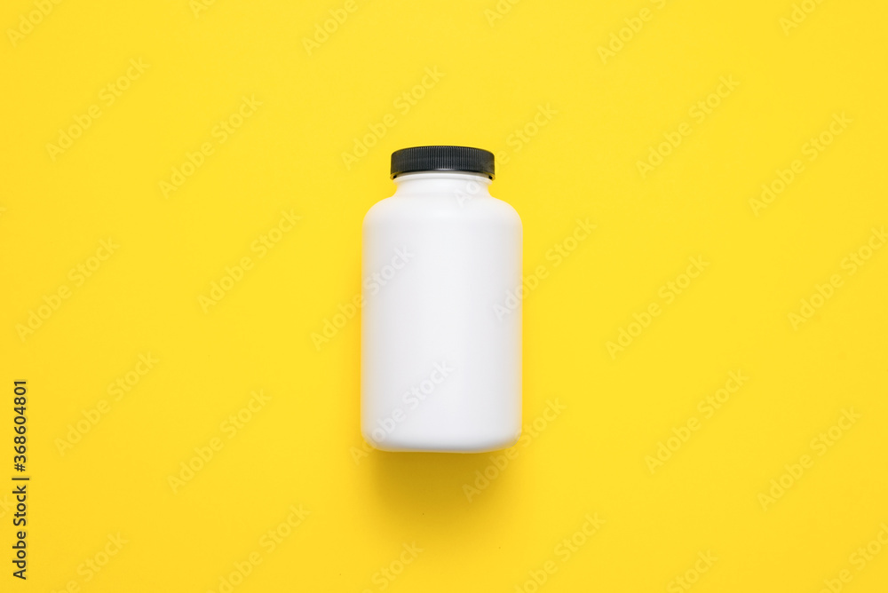 White plastic jars on the yellow flat lay background. White plastic jars on the yellow flat lay background.