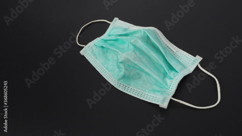 Used face mask or surgical mask on black background.