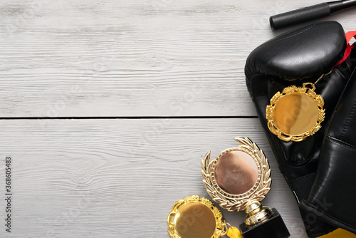 Boxing gloves and golden award trophy on the gray flat lay background with copy space.