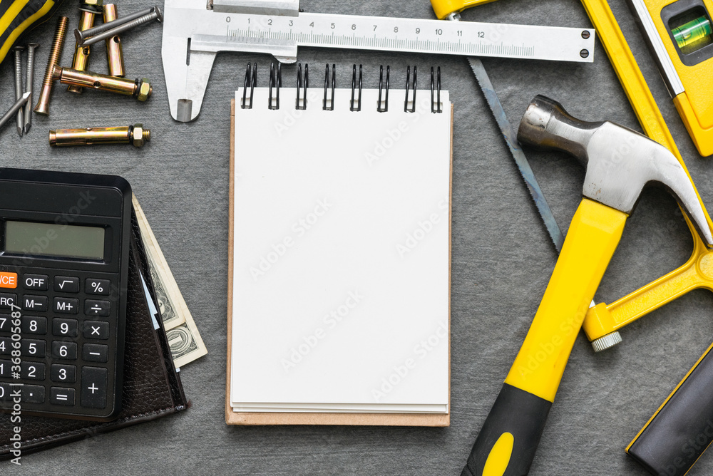Construction cost or repair calculation mockup. Blank page notepad and work tools on the workbench. - obrazy, fototapety, plakaty 