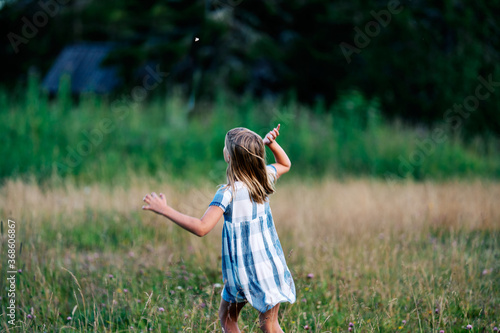 A girl chasing a butterfly in a flower meadow.  Shot at Holmenkollen  Oslo  Norway.