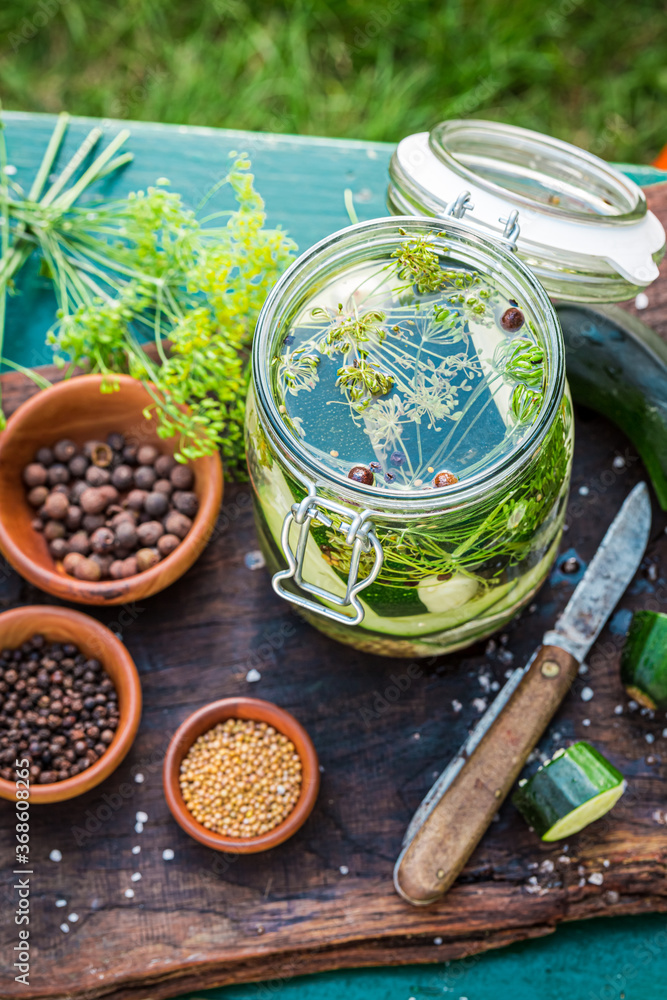 Pickled courgette in summer garden with charlock and allspice Pickled courgette in summer garden with charlock and allspice