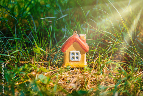 a toy house in the grass under the sun