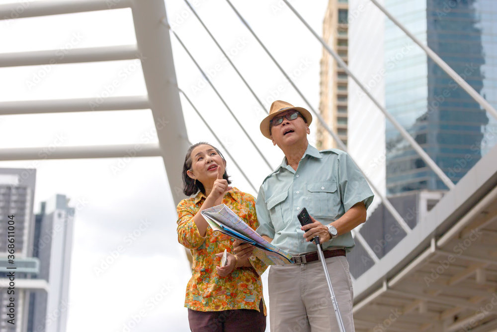 portrait of  happy senior couple walking on street with map