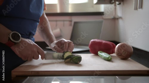 man cutting vegetables in the kitchen at home