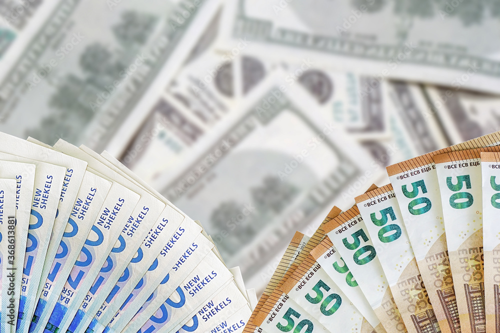Fan euro banknotes and new Israeli shekel. Fan 50 euro banknotes and 200 Israeli money banknotes on blur american dollars background. Fan euro banknotes and new Israeli shekel. Fan 50 euro banknotes and 200 Israeli money banknotes on blur american dollars background.