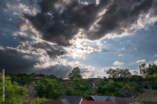 Dramatic sky over village in Franconian Switzerland on sunny summer day