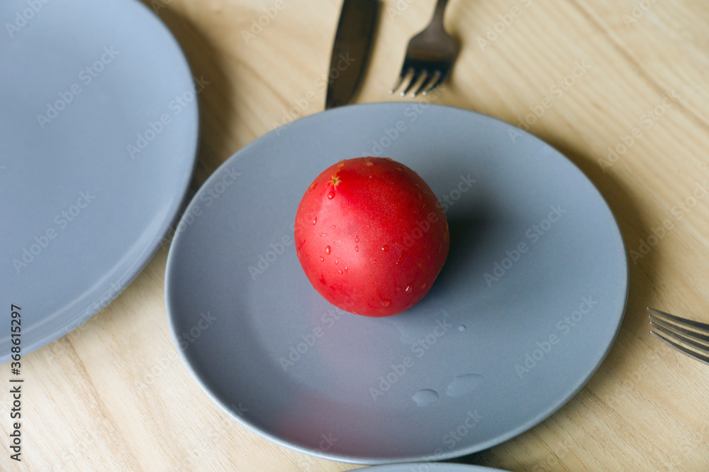 Whole red tomato on a plate Whole red tomato on a plate
