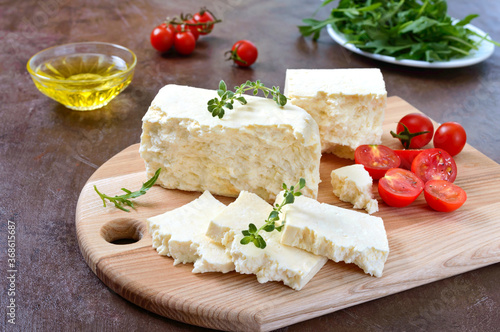 Delicious healthy sheep or goat feta cheese. Chunks of cheese on a wooden board.