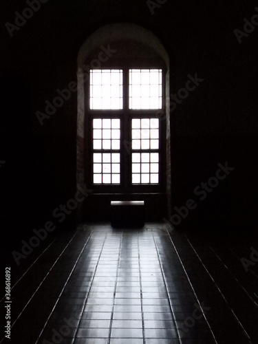dark hall with a window and a trunk