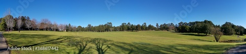 Beautiful morning panoramic view of a park with green grass, tall trees and deep blue sky, Fagan park, Galston, Sydney, New South Wales, Australia