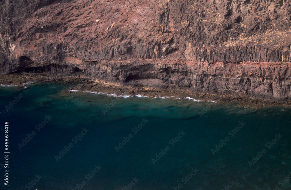 Obraz premium Gran Canaria, steep eroded coast line of Agaete municipality, path to Playa del Juncal beach