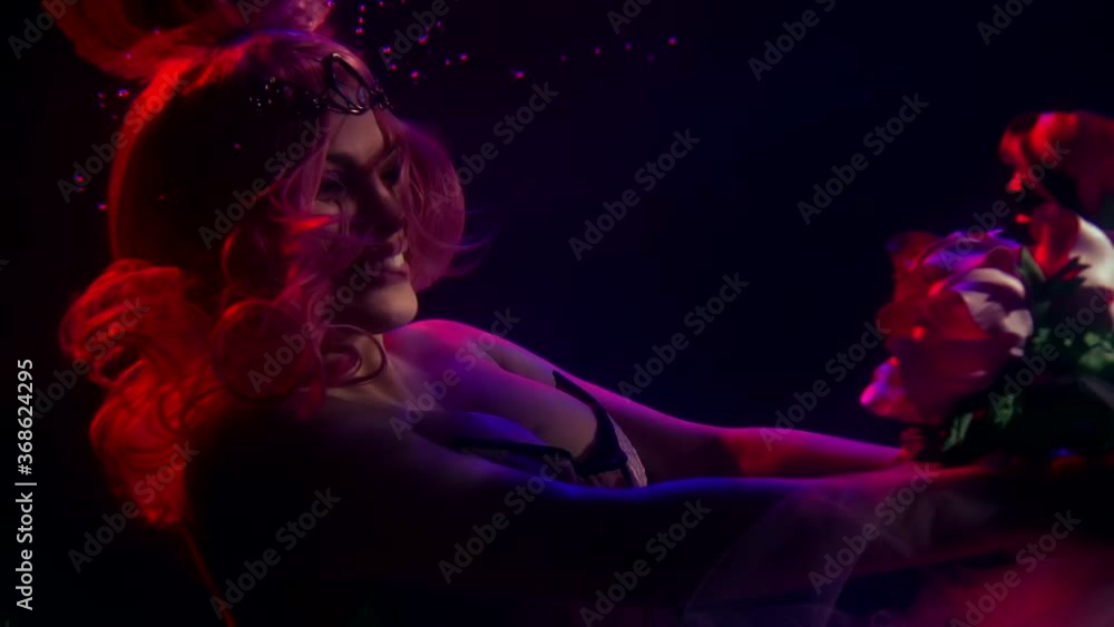 a woman with long red hair, wearing a tiara and a corset, floats in the dark under the water. she stretches a translucent fabric with flowers a woman with long red hair, wearing a tiara and a corset, floats in the dark under the water. she stretches a translucent fabric with flowers