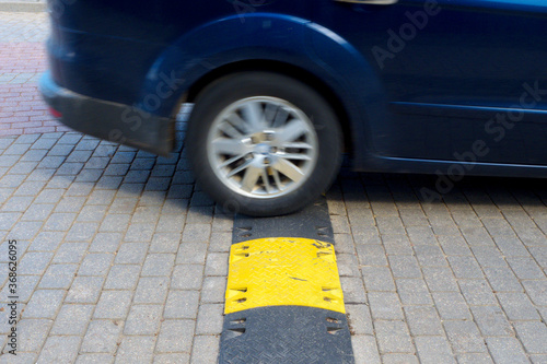A speed bump generally slows traffic, giving both people and cars time to react  Car in blur
