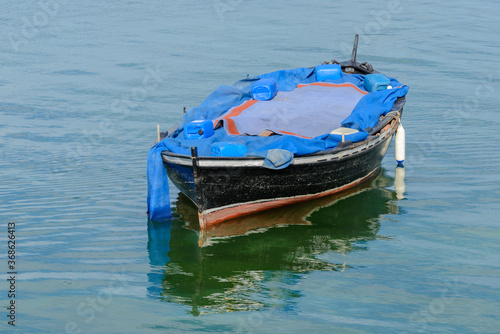 Fototapeta Naklejka Na Ścianę i Meble -  wooden fishing boat with a motor anchored in the sea, calm natural landscape