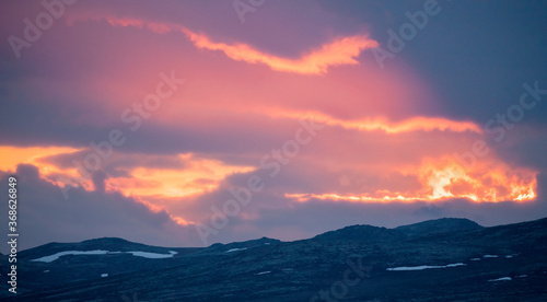 Panoramic shot of mountain scenery during sunset, blue hour and pink dramatic skies and light.