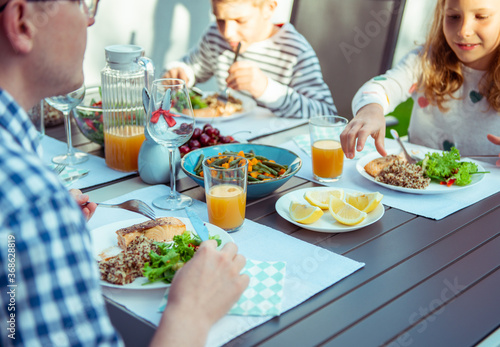 Happy family eating healthy dinner on terrace at home