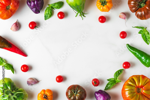 food composition. frame made of colorful organic vegetables. tomatoes  pepper  garlic and basil on white background