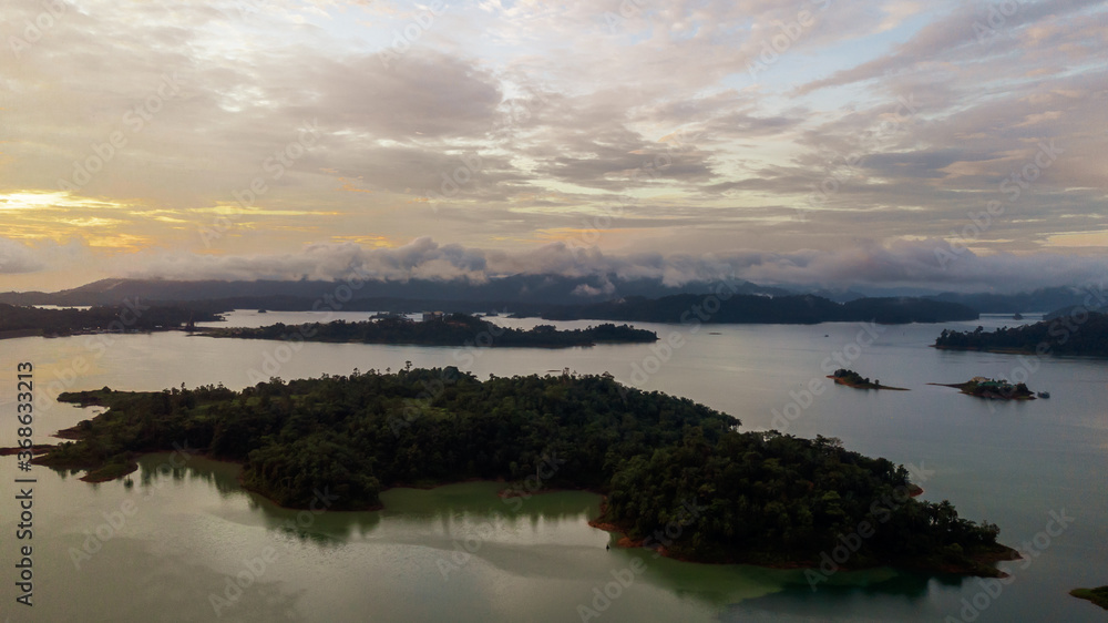 Aerial view of an amazing Colorful and Dramatic sunrise. Majestic Sunlight Cloud fluffy,Idyllic Nature Peaceful Background,Beauty Golden Hour near mountain on Kenyir Lake.