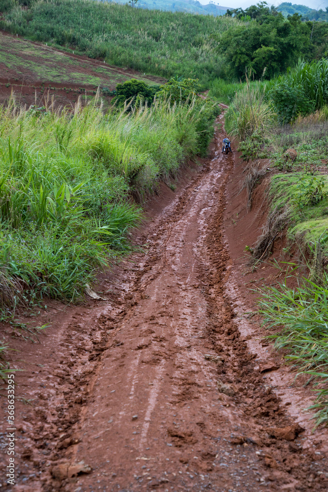 Muddy road with adventure to the forest in rainy season. Off road track. The road was filled with mud. When it rains, making dirt roads on the mountain as mud. Muddy road with adventure to the forest in rainy season. Off road track. The road was filled with mud. When it rains, making dirt roads on the mountain as mud.